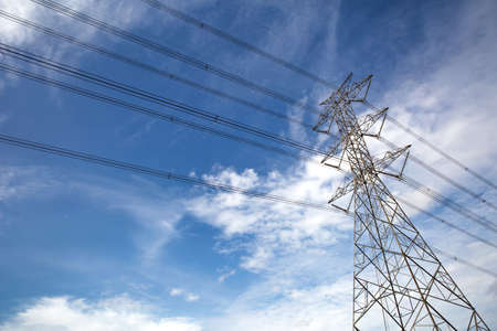 High-voltage transmission tower and wiring cable with sky background.
