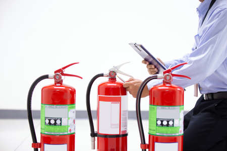 Fire engineering checking the red fire extinguishers tank in the building concepts of prevent case for emergency and safety rescue and fire training.の写真素材