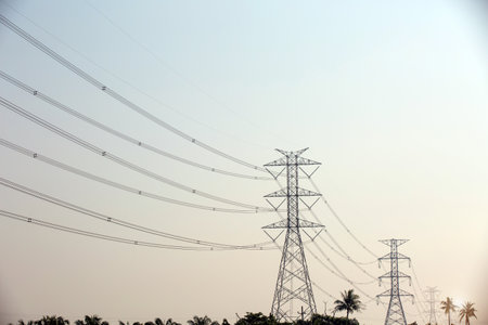 High-voltage transmission tower and electricity voltage wiring cable with sky background.の写真素材