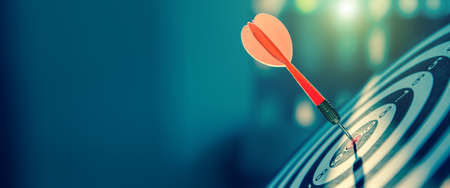bullseye target or dart board has red dart arrow throw hitting the center of a shooting for business targeting and winning goals business concepts.の写真素材