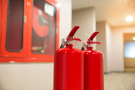 The red fire extinguisher is in the building.の写真素材