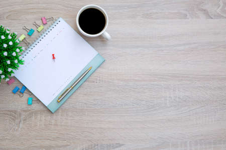 The top view desk and blank calendar with a pen and office equipment for working area copy space composition and work from home concepts.の写真素材