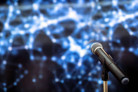 Public speaking backgrounds, Close-up the microphone on stand for speaker speech presentation stage performance with technology blur bokeh light background.の写真素材