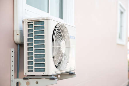 External split wall type of house air conditioner compressor unit installed on the outside of the building.の写真素材