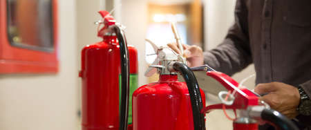 Fire engineering checking pressure gauge level of fire extinguishers tank in the building concepts of protection and prevent for emergency and safety rescue and fire training.の写真素材
