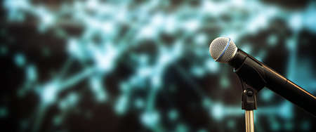 Public speaking backgrounds, Close-up the microphone on stand for speaker speech presentation stage performance with blur and bokeh light background.の写真素材