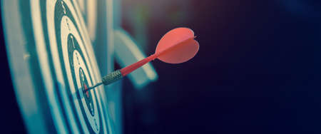 Close-up the bullseye or bulls eye target or dart board has dart arrow throw hitting the center of a shooting for business targeting and aim to winning goals conceptsの写真素材