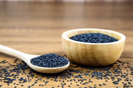 Black sesame seeds in a wooden spoon For healthy food and diet concepts.