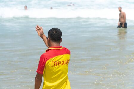 Lifeguard warning tourist to avoid dangerous area. At Patong beachの写真素材