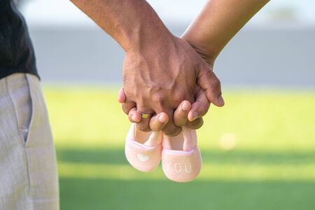 Farther and mother holding Small shoes for the unborn babyの写真素材
