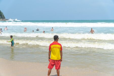 lifeguard man standing and looking with rescue can at the beachの写真素材