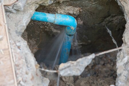 leaking water from blue pipe from undergroundの写真素材