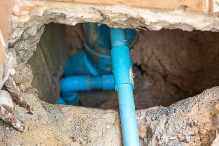 leaking water from blue pipe from undergroundの写真素材