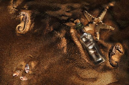Sea shells and stones in a bottle on sea-beach background. Photograph is made in lightbrush technique. Low-key lighting.の写真素材