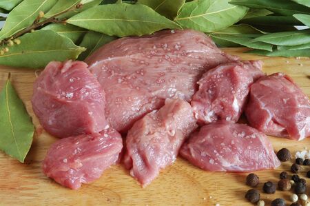 Raw beef meat with spice on wooden board