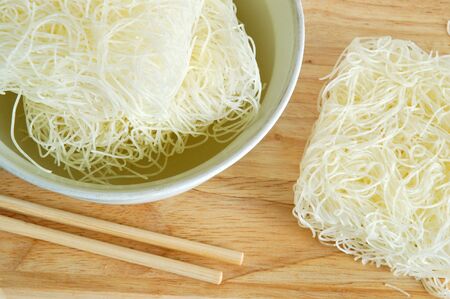 Asian rice and soy noodles in bowl with wooden chopsticksの写真素材