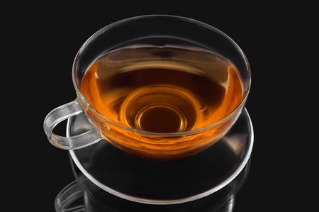 Class cup and saucer with green tea on black backgroundの写真素材