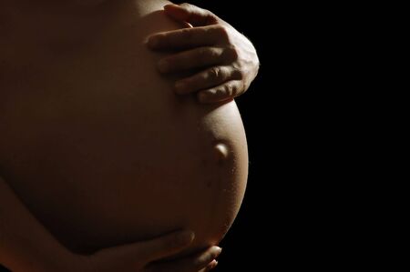Beautiful pregnant woman on black background