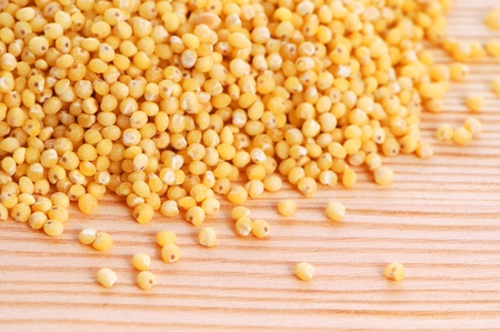 Millet seeds on a wooden background