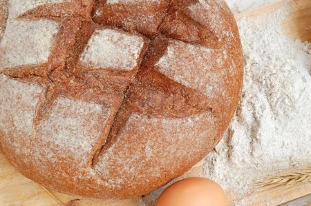 Homemade whole bread and flour on a white background
