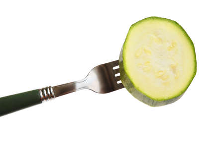 Green squash slice on a on a fork on a white backgroundの写真素材
