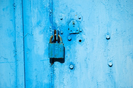 Locked steel covered door and padlockの写真素材