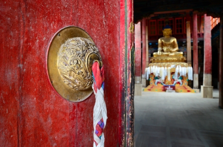 Old door in Buddhist monastery. The Buddha statite is visible in the background.のeditorial素材