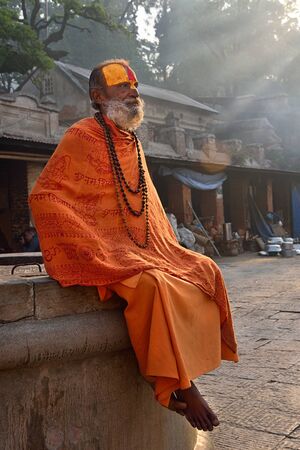 Kathmandu, Nepal - April 10, 2016: Hindu sadhu baba (holy man) in traditional dress sitting in...