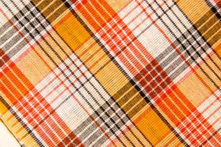 texture of white checkered, orange, red, black cotton fabric