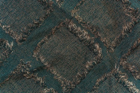 The background, texture of dark brown wool fabric with squares