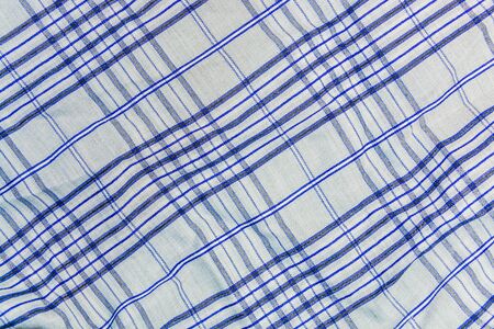 The background, texture of a checkered gray fabric with blue stripes