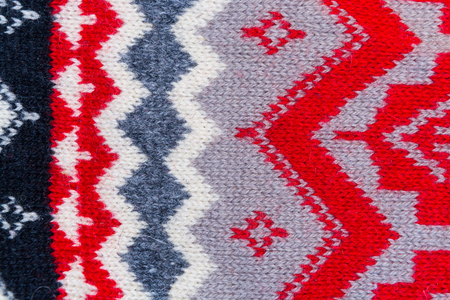 texture of wool with red, white, gray, blue geometric patterns