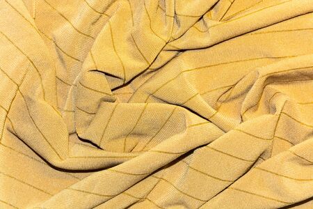 Knitted fabric draped striped ocher closeupの写真素材