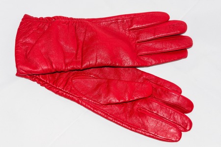 Female red leather gloves close-up on a white backgroundの写真素材
