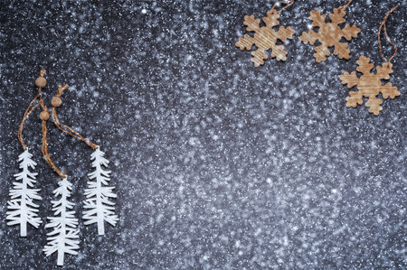 two white Christmas tree toys in the form of Christmas trees, tree wood snowflakes lie on a black background. snow effectの写真素材
