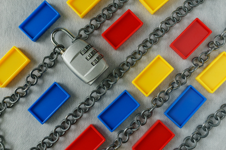 Chains with combination padlock and colorful plastic block as safety banking block chain concept.
