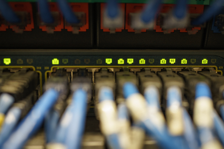 Selective focus on indicator light on network lan cable plug connector port.
