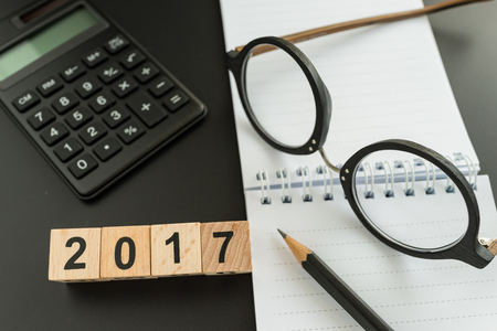 financial target concept as selective focus on number 2018 wooden block with glasses, calculator,...