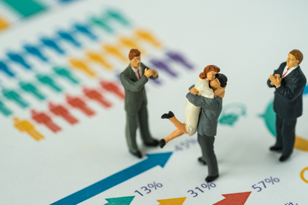 Miniature people with couple standing on printed gender report as couple life style analysis concept.の写真素材