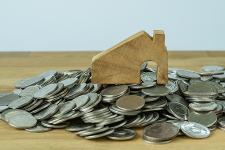 wooden miniature house on top of stack of coins as financial saving or mortgage house loan concept.の写真素材