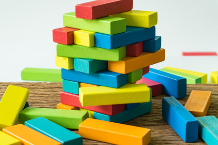 fail and collapse colorful wooden block tower in as Risk or stability concept.