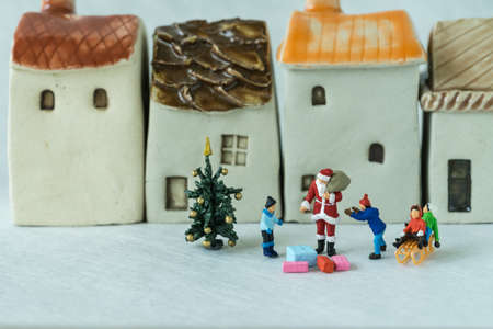 Christmas celebration story with miniature figure Santa claus giving present to happy children.の写真素材