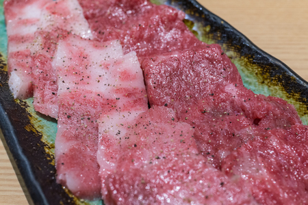 Selective focus on macro view of fresh A5 japanese supreme beef yakiniku cuisine with pepper and salt glaze.の写真素材