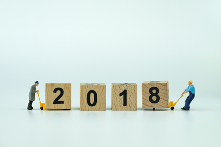 New year 2018 celebration with miniature workers small figure help using hand manual forklift to move wooden block with numbers 2018.の写真素材