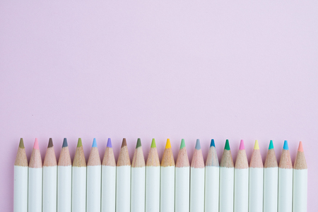 Cute pastel color pencils on pink paper background with copy space using as coloring or art concept.の写真素材