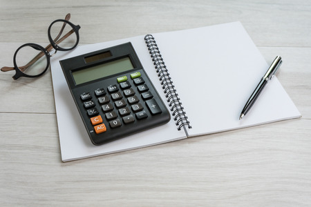 Pen and calculator on white notebook with eyeglasses using as business accounting or tax calculation concept.の写真素材