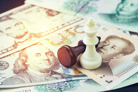 US and China finance tariff trade war concept, black loser and white winner chess king on US dollar and china yuan banknotes, world major market countries, import and export barrier.の写真素材