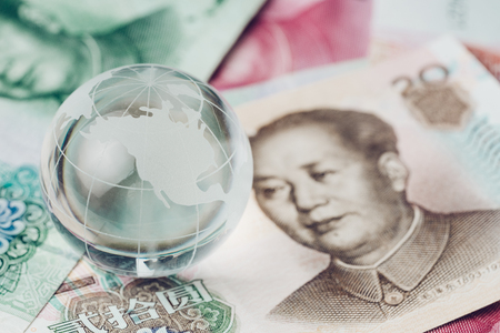 US and China trade war, tariff, tax barrier, decoraton glass globe with the side of United States map on China yuan banknotes.の写真素材