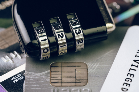 Credit card online payment data security concept, combination code lock pad on pile of credit cards,...