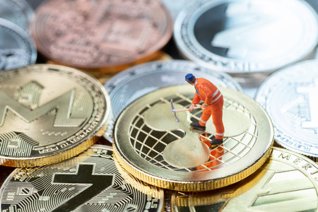 Cryptocurrency mining concept, miniature worker minor standing on various golden physical digital money Ripple, xrp.の写真素材